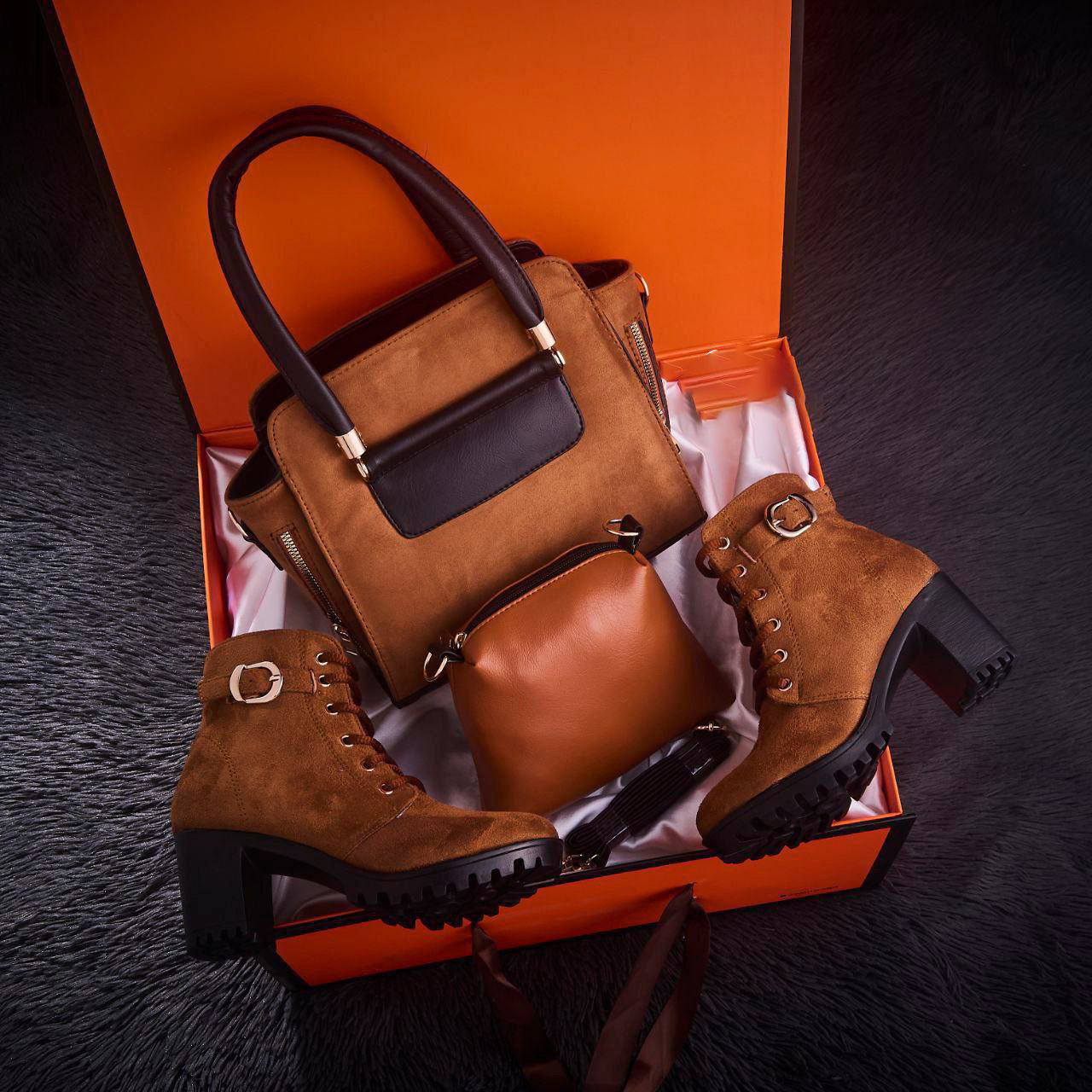 مجموعة من الأحذية الطويلة حتى الركبة وحقيبة من جلد الغزال