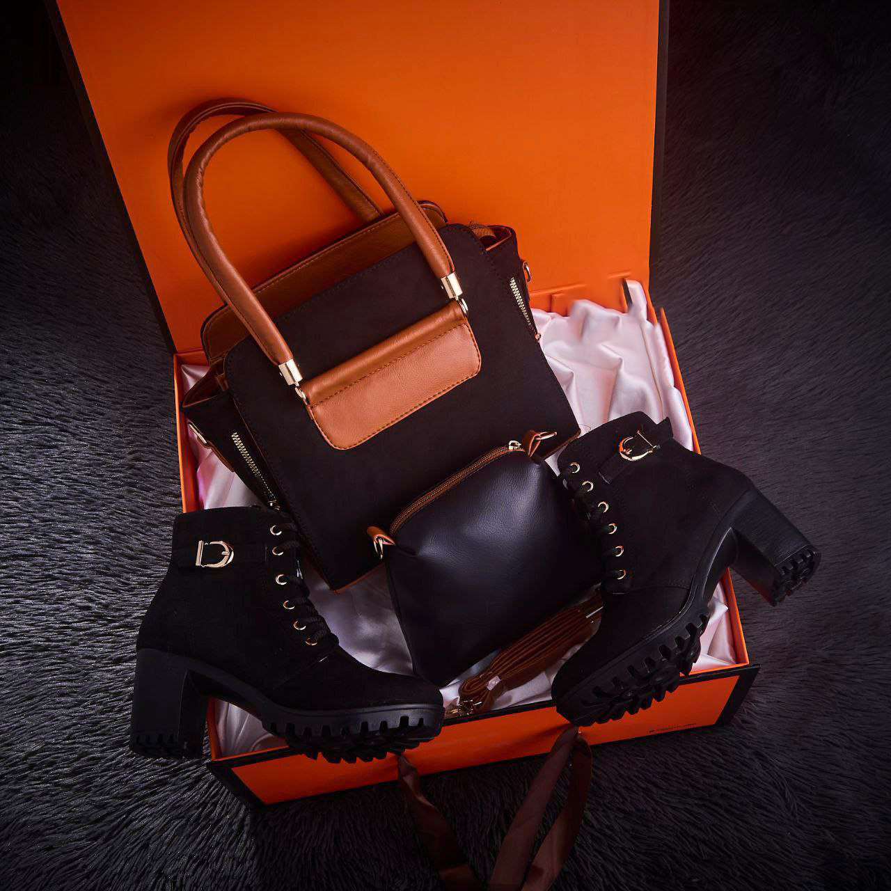 مجموعة من الأحذية الطويلة حتى الركبة وحقيبة من جلد الغزال